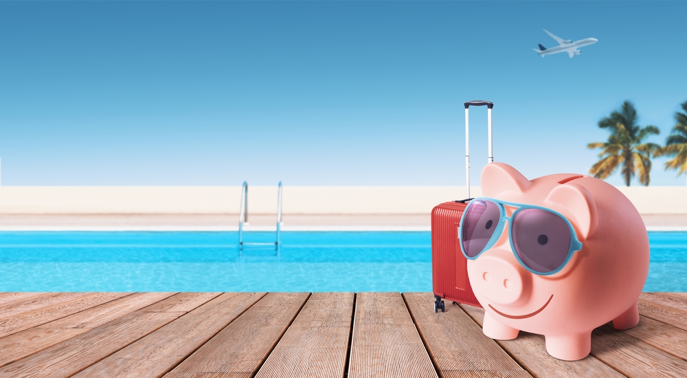 happy,piggy,bank,with,luggage,and,sunglasses,at,the,resort,