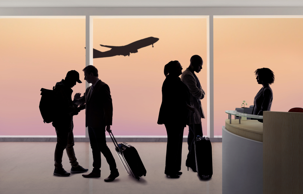 silhouettes,of,passengers,waiting,in,line,at,an,airport,check