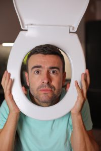 comedian,holding,toilet,part,aorund,his,face